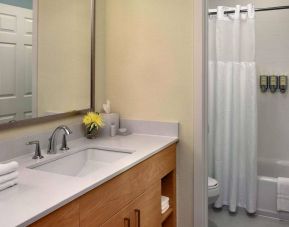 Guest bathroom in Sonesta ES Suites Auburn Hills Detroit, furnished with bath, lavatory, sink, and mirror.