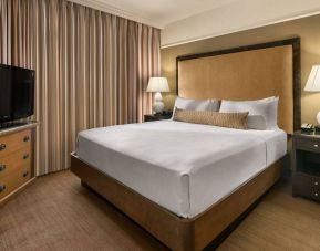 Double bed guest room in Sonesta Suites Scottsdale Gainey Ranch, featuring window, bedside lamps, and television.