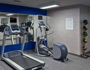 The hotel fitness center is equipped with towels, gym balls, and exercise machines such as an elliptical and a treadmill.