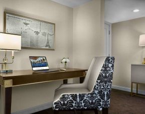 The Chase Park Plaza Royal Sonesta St. Louis guest room workspace, furnished with desk, chair, and lamp.
