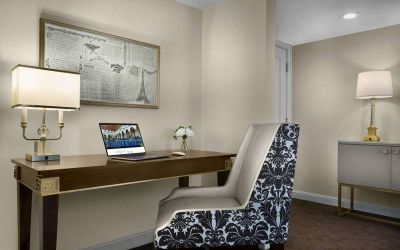 The Chase Park Plaza Royal Sonesta St. Louis guest room workspace, furnished with desk, chair, and lamp.