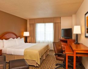 Double bed guest room in Sonesta Atlanta Airport South, featuring TV, window, and workspace desk and chair.