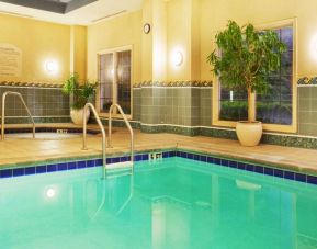 Sonesta Atlanta Airport South’s indoor pool has a hot tub nearby, potted plants by the side, and large windows.