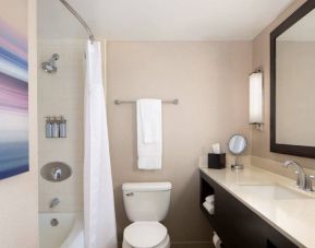 Guest bathroom in Sonesta San Jose, featuring bath with a shower, lavatory, and window and sink.