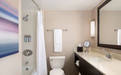 Guest bathroom in Sonesta San Jose, featuring bath with a shower, lavatory, and window and sink.