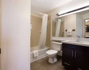 Guest bathroom in Sonesta Simply Suites St Louis Earth City, with bath, lavatory, long mirror, and sink.