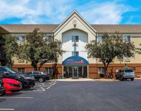 Sonesta Simply Suites St Louis Earth City’s exterior includes numerous parking spaces (including disabled spaces near the covered entrance) and trees.