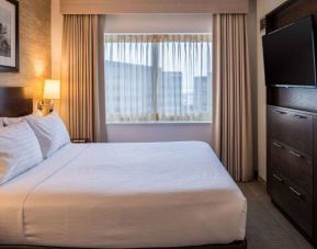 Sonesta Chicago O'Hare Airport Rosemont double bed guest room with window and wall-mounted TV.