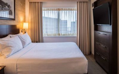 Sonesta Chicago O'Hare Airport Rosemont double bed guest room with window and wall-mounted TV.