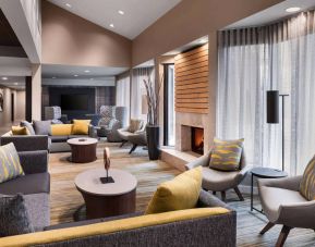 Sonesta Select Newport Middletown’s lobby lounge is furnished with comfy chairs and corners sofas, a fireplace and coffee tables, plus large windows.