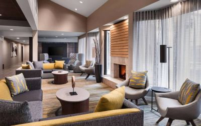 Sonesta Select Newport Middletown’s lobby lounge is furnished with comfy chairs and corners sofas, a fireplace and coffee tables, plus large windows.