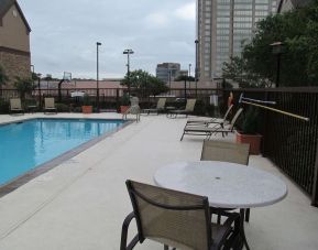 Sonesta ES Suites San Antonio Northwest - Medical Center’s outdoor pool is ringed by a fence, and has nearby tables and chairs, as well as sun loungers.