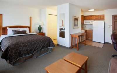 Double bed guest room in Sonesta ES Suites San Antonio Northwest - Medical Center, featuring kitchen area with fridge-freezer and microwave.
