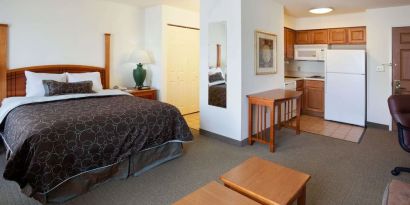 Double bed guest room in Sonesta ES Suites San Antonio Northwest - Medical Center, featuring kitchen area with fridge-freezer and microwave.