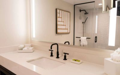 Royal Sonesta San Juan guest bathroom, including shower, sink, and mirror, plus art on the wall.