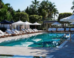 Nautilus by Sonesta’s outdoor pool has sun loungers (with shade available) by the side, and palm trees looming in the background.