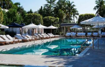 Nautilus by Sonesta’s outdoor pool has sun loungers (with shade available) by the side, and palm trees looming in the background.