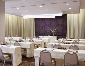 The Shelburne Sonesta New York meeting room with tables arranged in a classroom style facing a head table and space for over a dozen attendees.