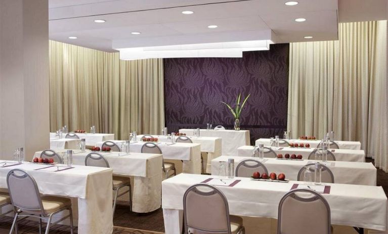 The Shelburne Sonesta New York meeting room with tables arranged in a classroom style facing a head table and space for over a dozen attendees.