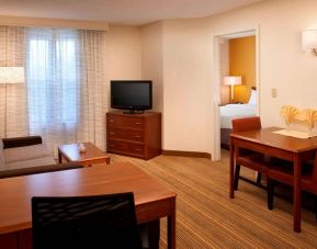 Sonesta ES Suites Chicago Waukegan Gurnee double bed guest room lounge area, featuring sofa, coffee table, and TV.