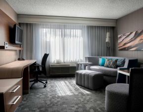 Sonesta Select Tempe Downtown guest room living area, including window, chairs, TV, and sofa.