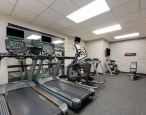 The fitness center in Sonesta Select Tempe Downtown has a wall-mounted TV, free weights, and exercise machines facing a large mirror.