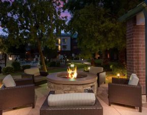 Sonesta Select Tempe Downtown’s fire pit is surrounded by armchairs, with trees nearby and the pool just steps away.