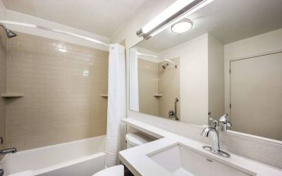 Guest bathroom in Sonesta Simply Suites Phoenix Tempe, including shower, bath, lavatory, and sink.