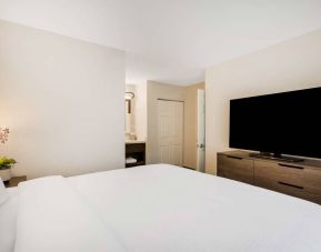 Sonesta ES Suites Denver South - Park Meadows double bed guest room, including bedside lamp and large TV.