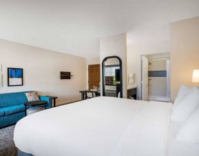 Double bed guest room in Sonesta ES Suites Denver South - Park Meadows, including sofa, mirror, coffee table, and ensuite bathroom.
