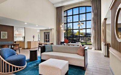 The lobby lounge in Sonesta ES Suites Denver South - Park Meadows has tables and chairs, plus sofa seating, a high ceiling and large windows for plenty of natural light.