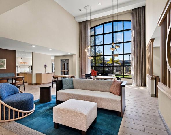 The lobby lounge in Sonesta ES Suites Denver South - Park Meadows has tables and chairs, plus sofa seating, a high ceiling and large windows for plenty of natural light.