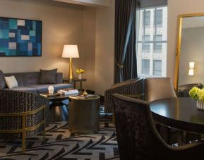 Lounge within a guest room of The Allegro Royal Sonesta Hotel Chicago Loop, including sofa, armchairs, coffee tables, and a window.