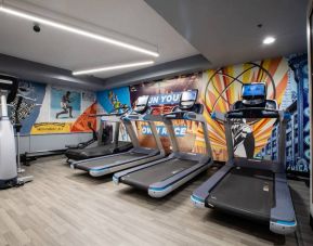 The fitness center in The Allegro Royal Sonesta Hotel Chicago Loop has assorted types of exercise machine and motivational artwork on the wall.