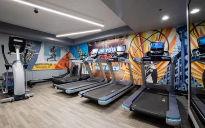 The fitness center in The Allegro Royal Sonesta Hotel Chicago Loop has assorted types of exercise machine and motivational artwork on the wall.
