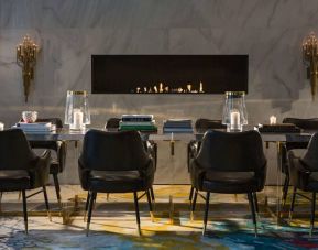 The Allegro Royal Sonesta Hotel Chicago Loop’s lobby lounge includes a table, comfortable seating, and a fireplace.