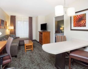 Sonesta ES Suites Atlanta - Perimeter Center double bed guest room, with living area that has a desk and chair, sofa, coffee tables, window, and TV.