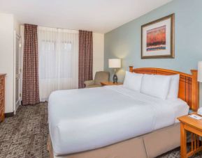 Sonesta ES Suites Atlanta - Perimeter Center double bed guest room, featuring TV, armchair, and window.