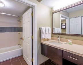 Guest bathroom in Sonesta ES Suites Atlanta - Perimeter Center, with shower and bath, sink and mirror.