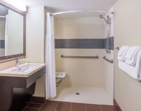 Guest bathroom in Sonesta ES Suites Atlanta Alpharetta Avalon featuring shower with curtain, mirror, and sink.