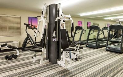 Sonesta Simply Suites Detroit Troy’s fitness center includes free weights, a mirrored wall, and various types of exercise machine.