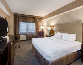 Double bed guest room in Sonesta White Plains Downtown, featuring window, armchair, and TV.