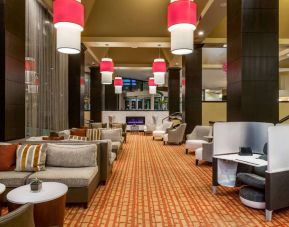 Sonesta White Plains Downtown’s lobby lounge is furnished with sofa and armchair seating, coffee tables, and a fireplace.