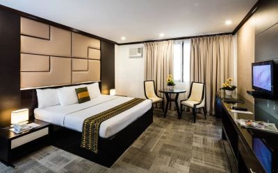 King room with chairs and work space at Apo View Hotel.