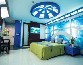 Dreamworld Araneta double bed guest room, furnished with an aquatic theme, including blue decor and images of fish, plus tables and chairs.