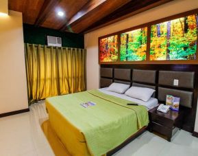 Dreamworld Araneta double bed guest room, featuring bedside telephone and artwork of an autumnal forest.