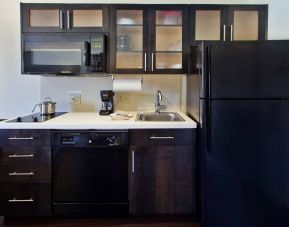 Guest room kitchen in Sonesta Simply Suites Oklahoma City Airport, furnished with microwave, hob, and fridge-freezer.
