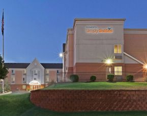 Sonesta Simply Suites Oklahoma City Airport’s exterior has a USA flag, abundant greenery including well-trimmed bushes, and the hotel chain’s name clearly indicated.