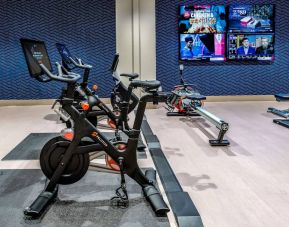The fitness center in Sonesta Columbus Downtown has an assortment of exercise machines and multiple widescreen TVs on the wall.