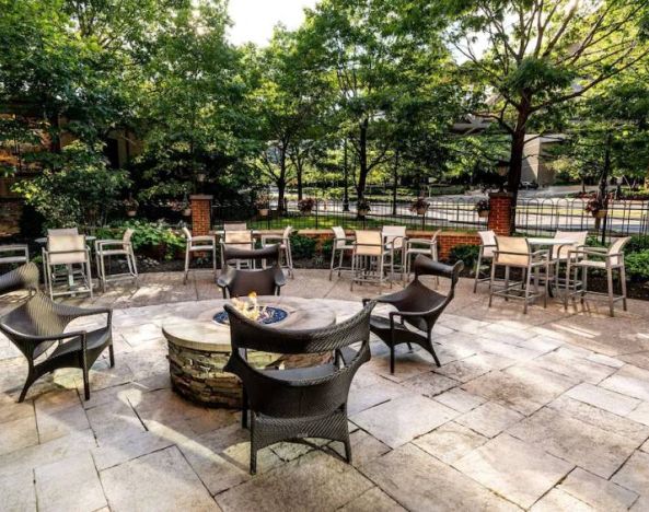 Sonesta Columbus Downtown’s patio features a fire pit that is surrounded by chairs with more tables and chairs nearby.